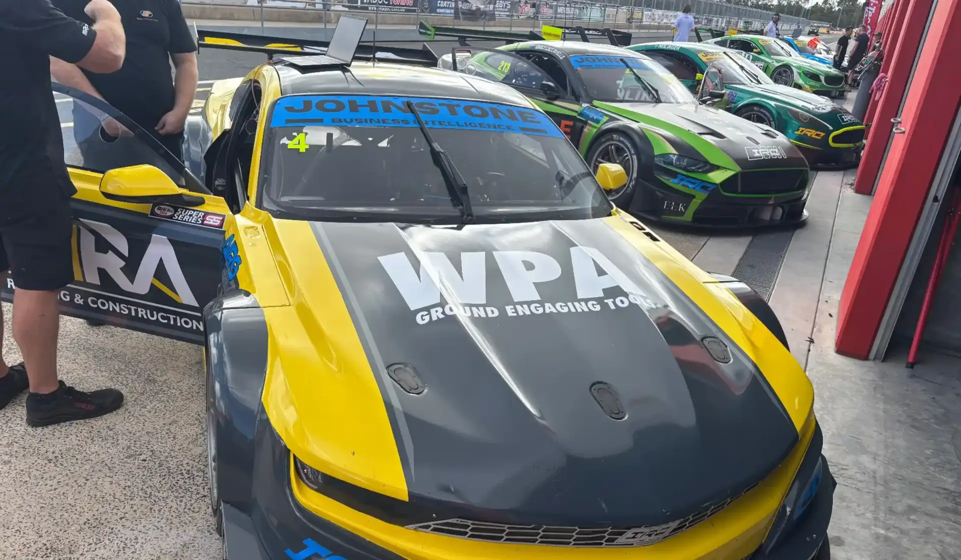 Australian Innovation Race Cars in the pit lane, with Johnstone Business Intelligence as 2026 Series Sponsor